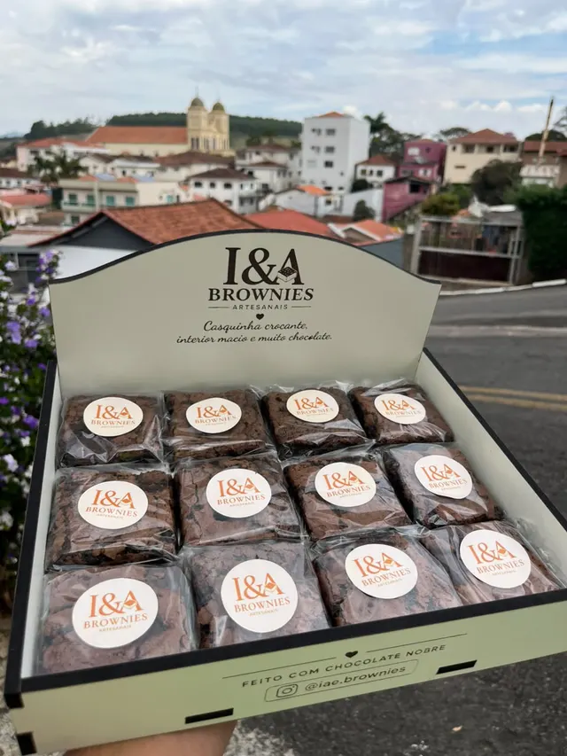 Caixa da I&A com 12 brownies embalados, com a cidade ao fundo